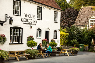 A young couple enjoying a drink outside a country pub in Hampshire
