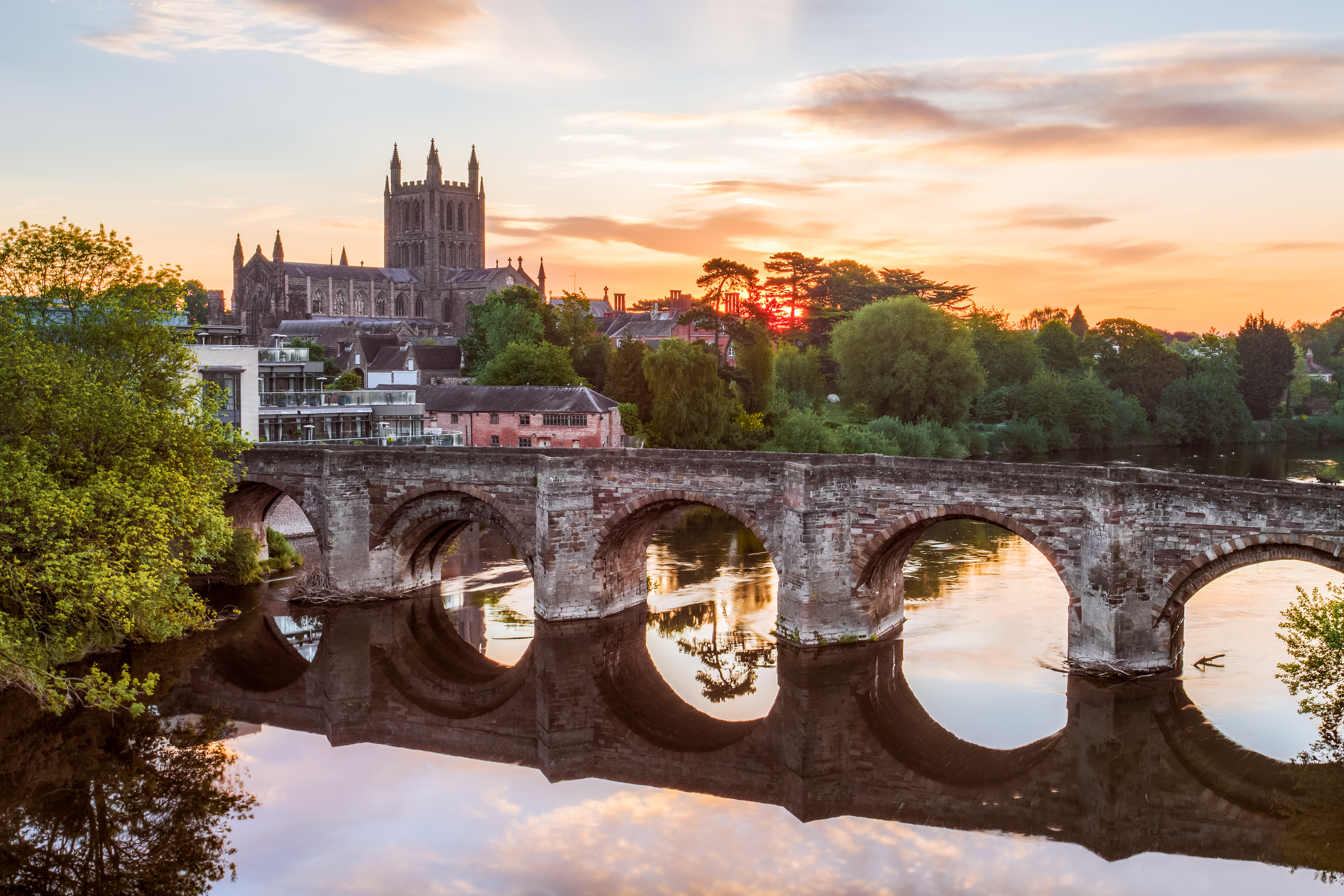 The River Wye crossed by a stone bridge and Hereford Cathedral in the near distance 
