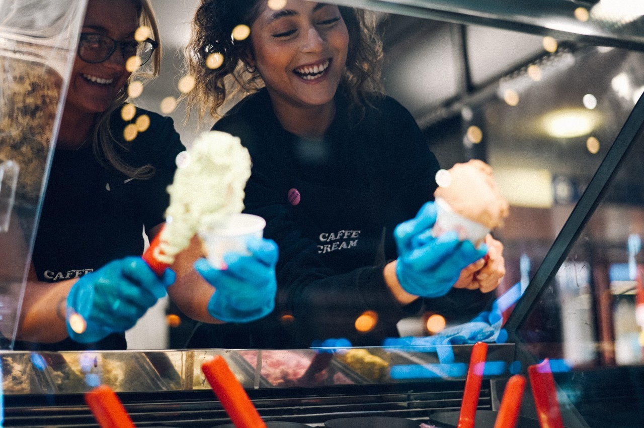 Two smiling women serving ice cream at Woodside Food Market