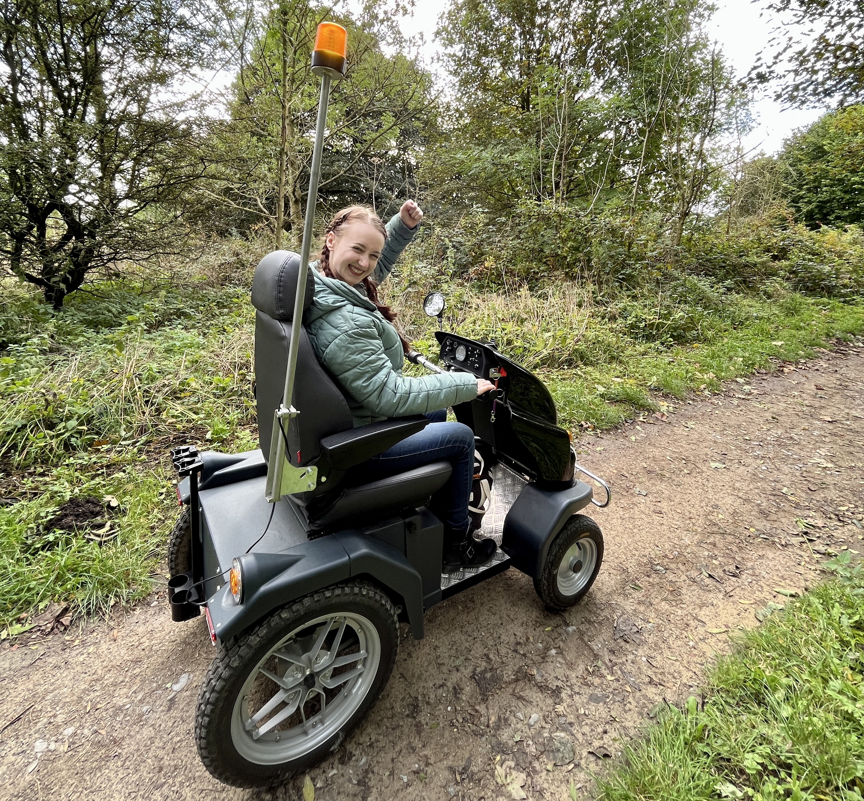 Young woman in an accessible Tramper on a path surrounded by woods in Sutton Bank