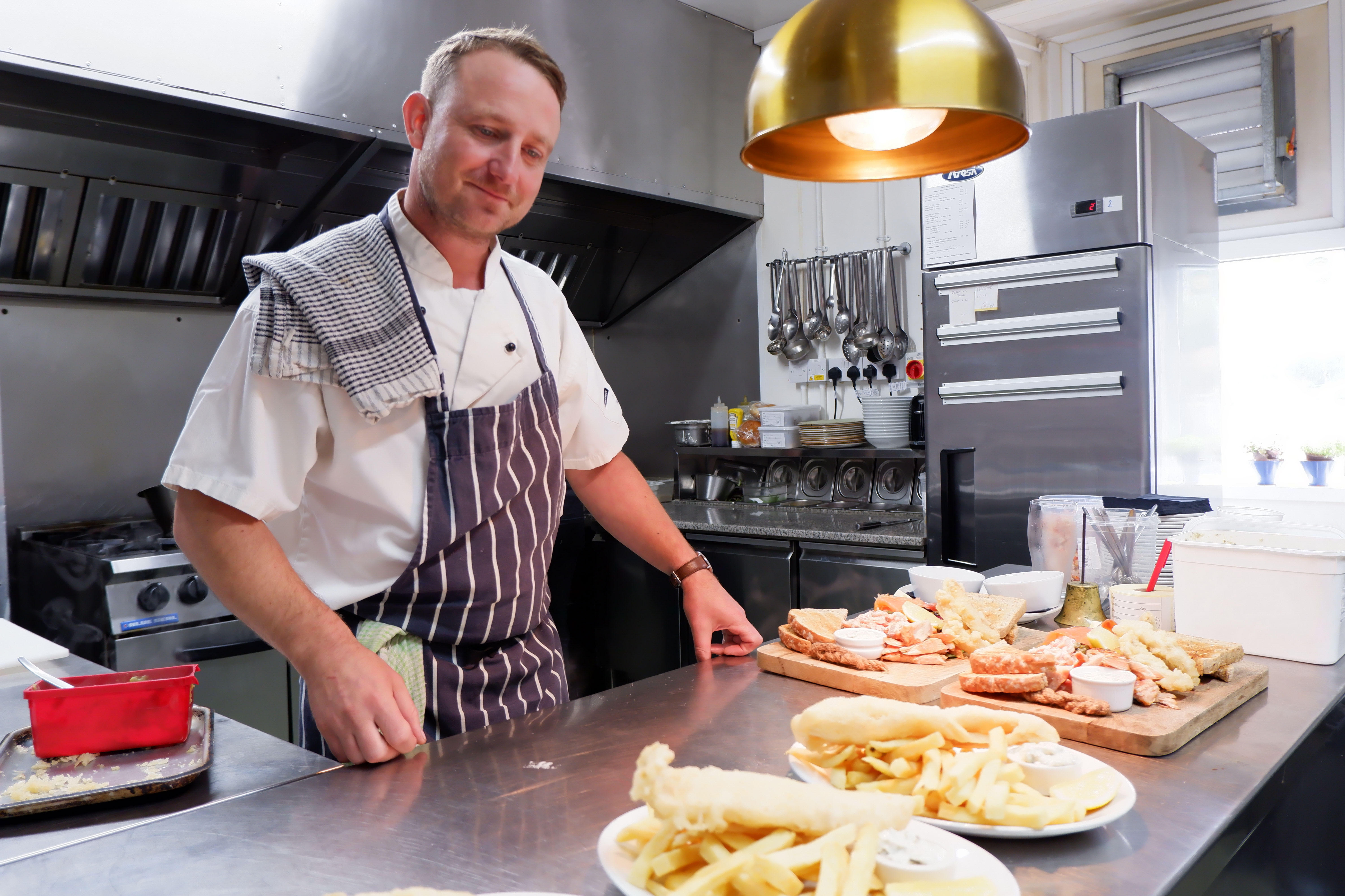 Chef with food in pub kitchen