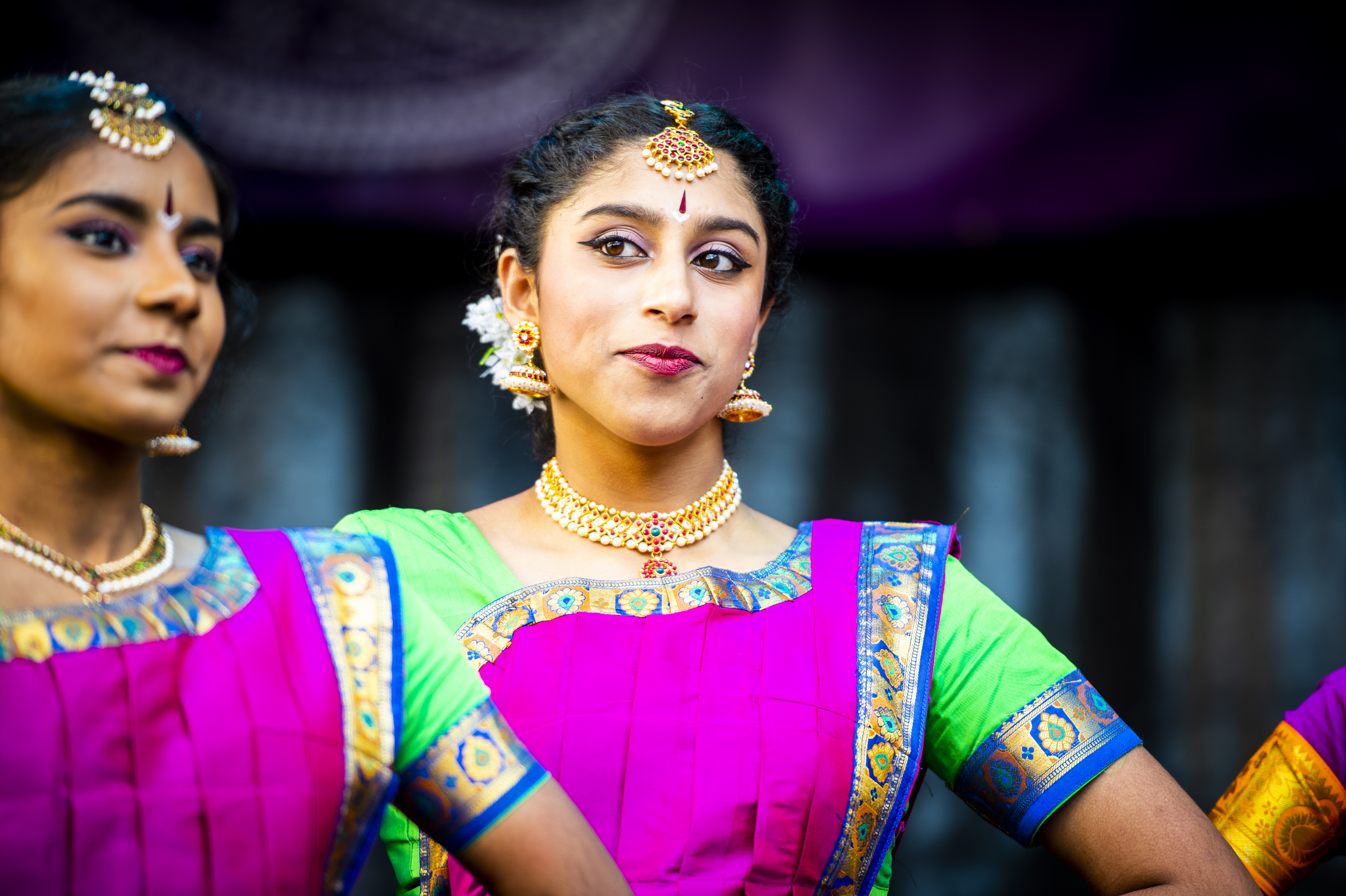 Two female Indian dancers in purple and green trim saris