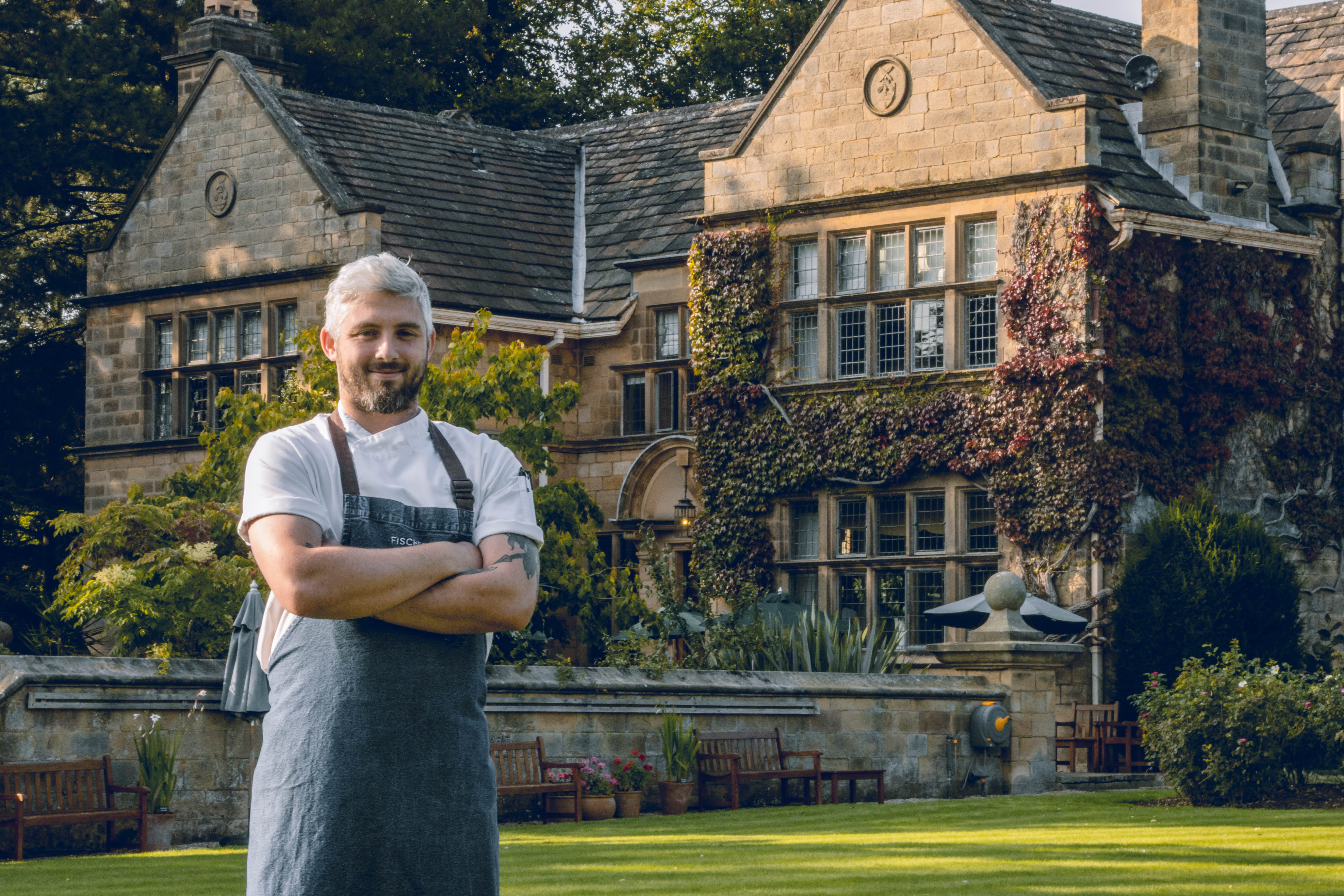 A chef stands outside Fischer's Baslow Hall, a luxury countryside hotel and restaurant 