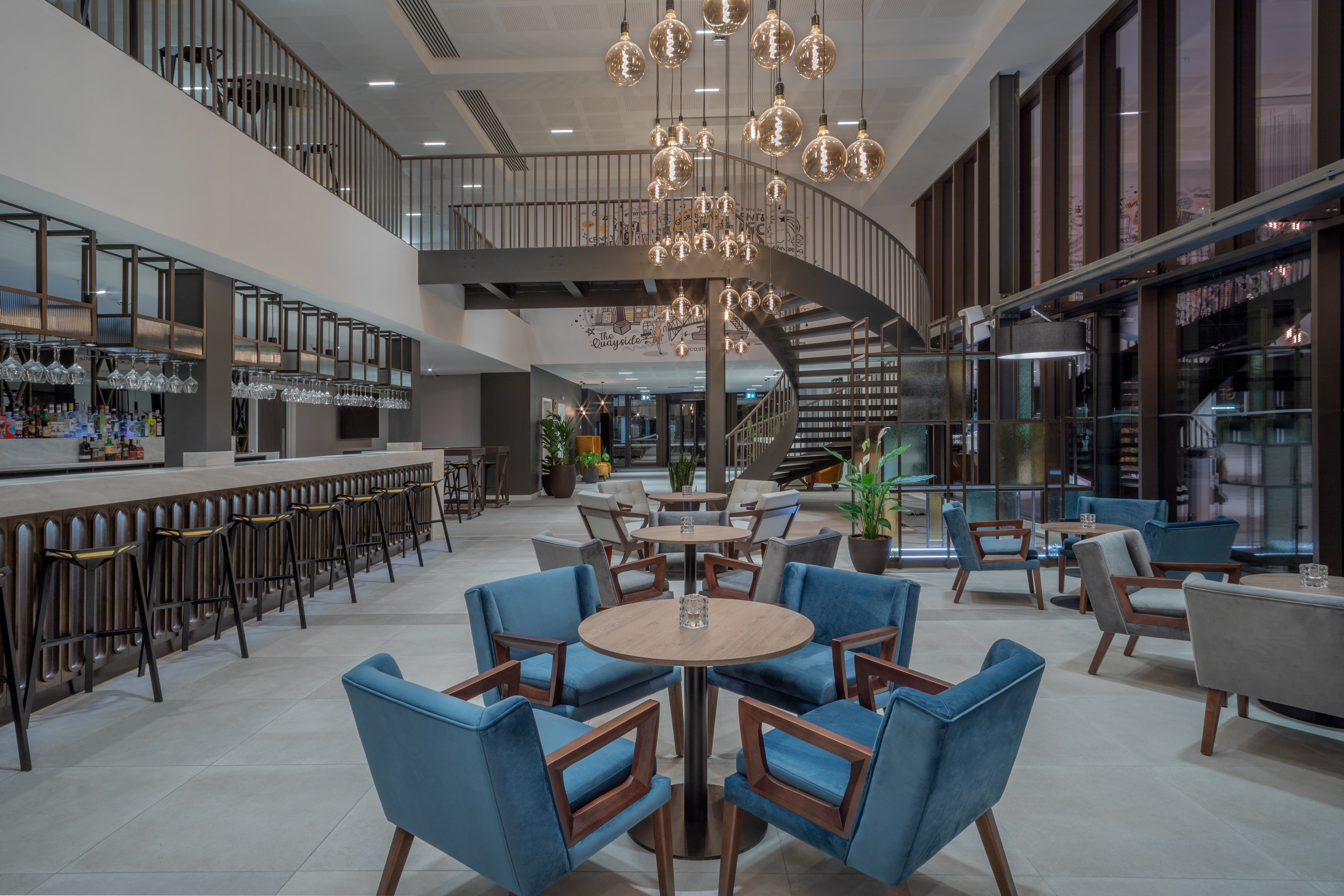 Hotel bar with tables, chairs and chandelier at INNSiDE by Melia