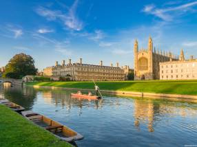 View of college in Cambridge with people punting on River Cam