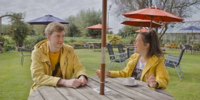 Rosie Jones and James Acaster sitting at pub garden table