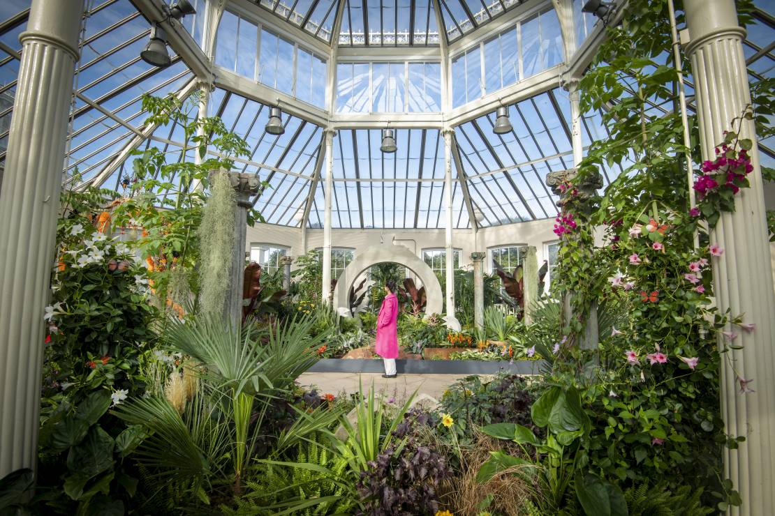 A visitor enjoys Surreal Pillars of Mexico, a horticultural display by Jon Wheatley at Kew Gardens