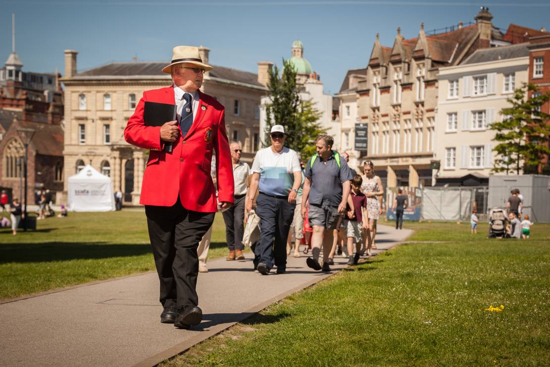 Man in red uniform leading a group of tourists