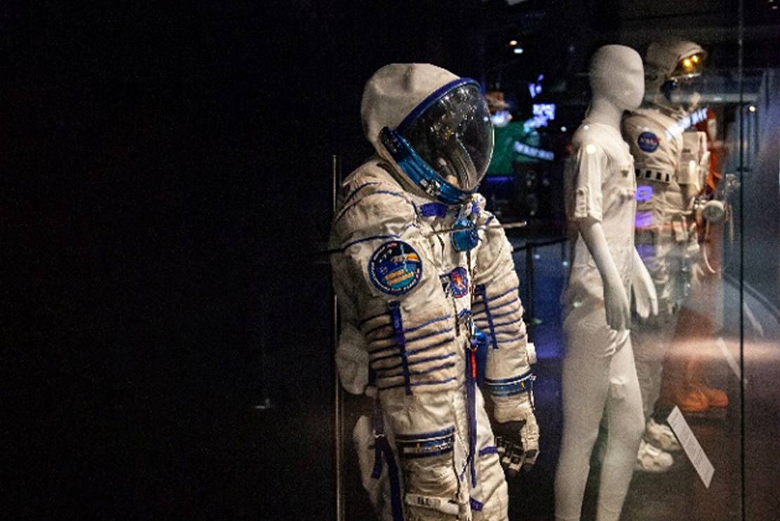 Astronaut suits on display behind glass
