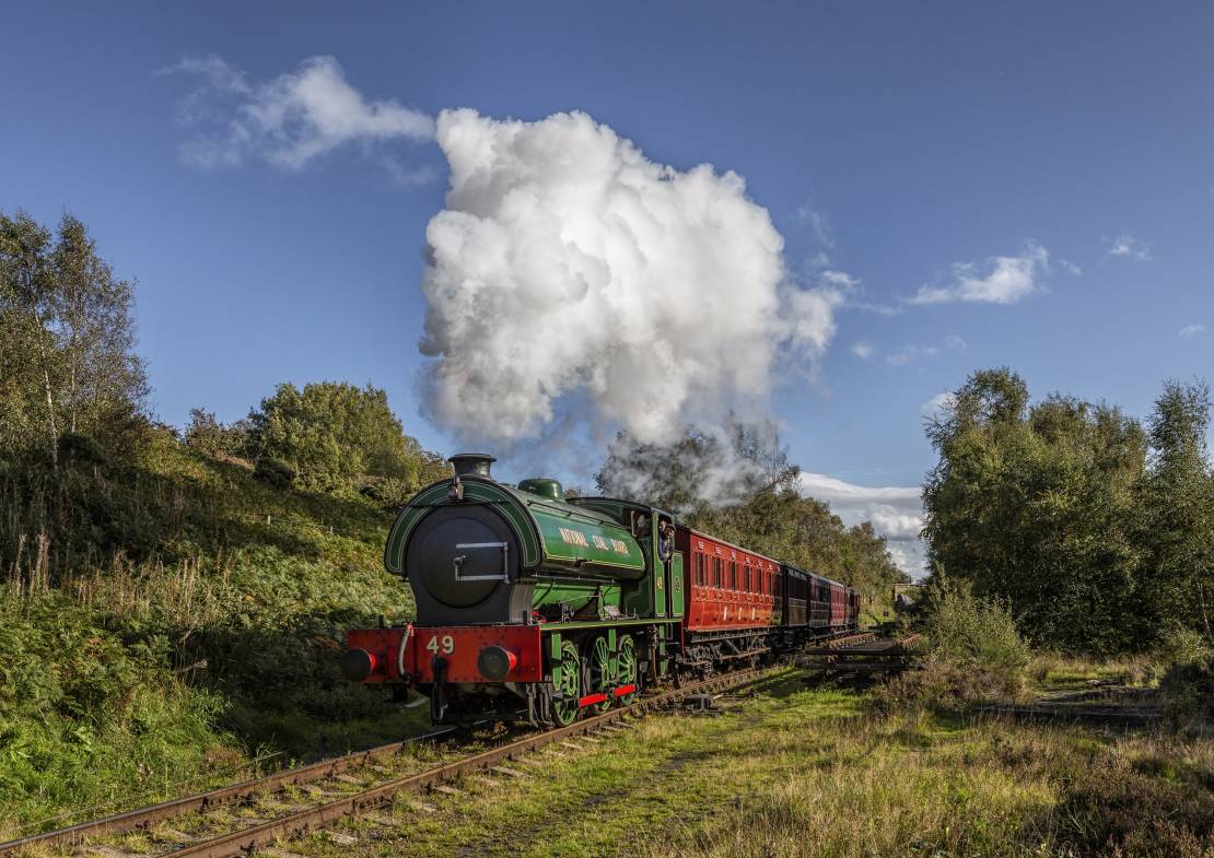 Steam locomotive N.C.B No.49 with a colliery passenger train steaming along the Tanfield Railway, the World's Oldest Railway in North East England