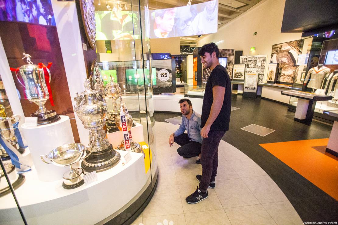 Two people looking at trophy in glass case