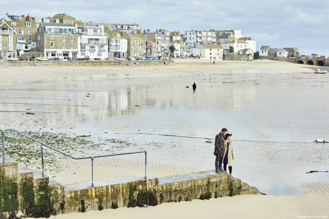 A couple visiting the small town of St Ives, a well known beach resort, historic town and cultural centre on the North Cornish coast. Walking on the seafront.