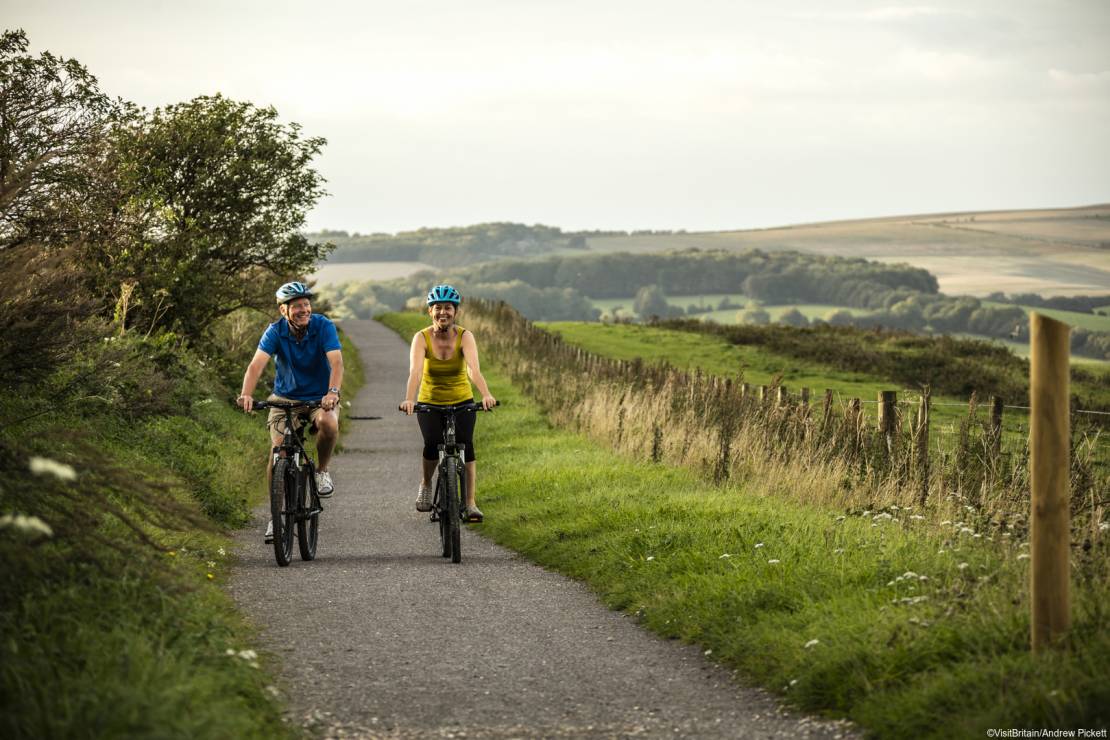 Two people cycling on a cycle path in the South Downs national park.