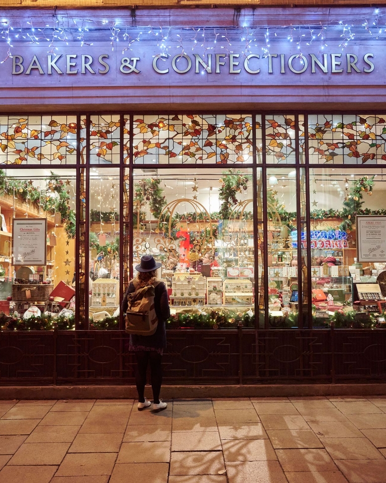 Woman looking into a shop window in the evening at Christmas