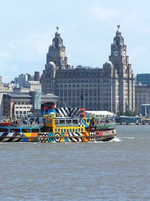 A view to a ferry on a river in front of an iconic building