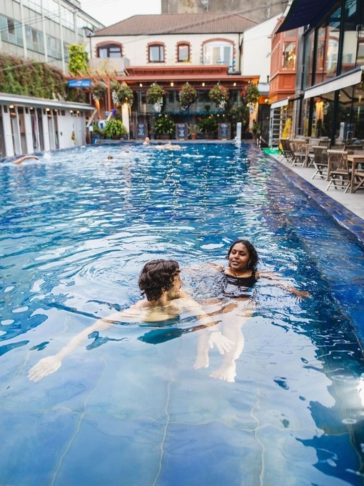 Man and woman enjoy a swim in an outdoor swimming pool