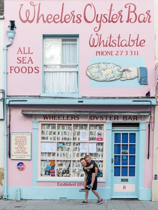 Two boys outside pink shopfront