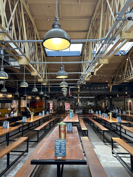 Interior view of market with rows of tables and benches 