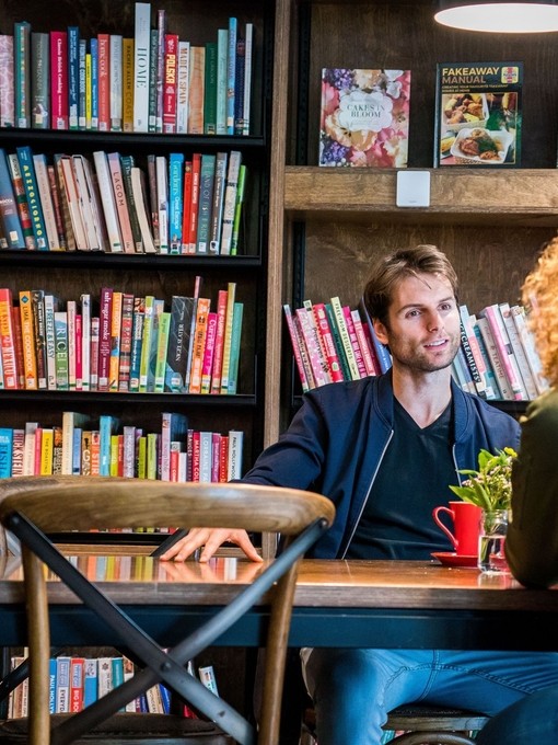 A man and woman having a coffee in a library