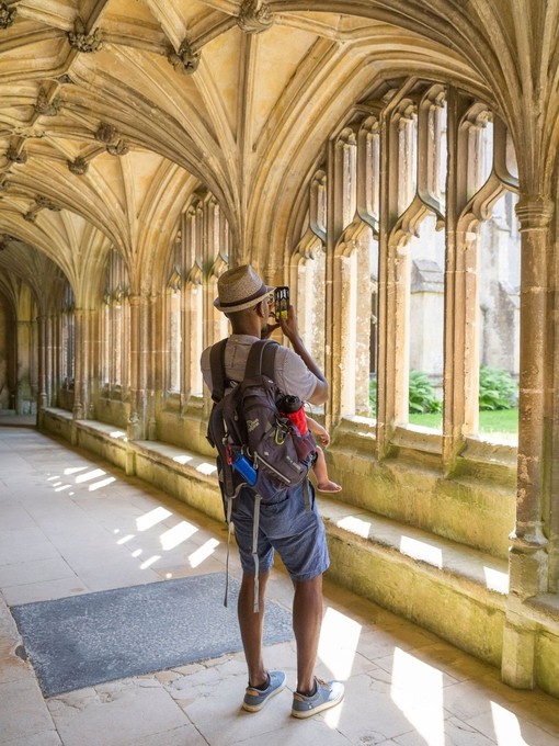 Visitors exploring the medieval cloisters at Lacock Abbey and village, Wiltshire