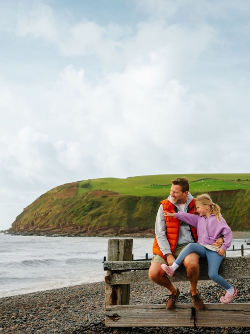 Father and daughter having fun on a beach