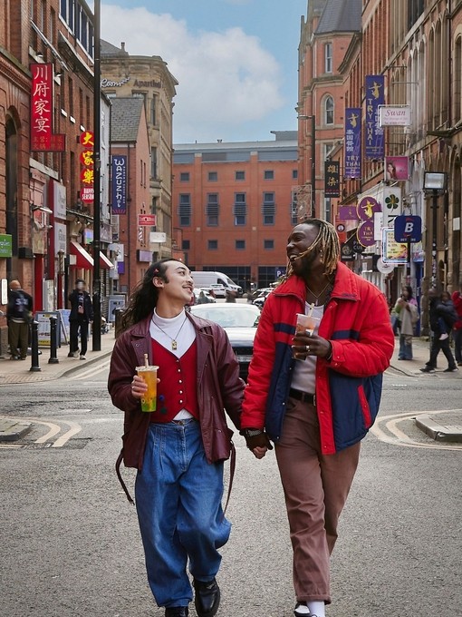 Two men chatting, exploring a city Chinatown.