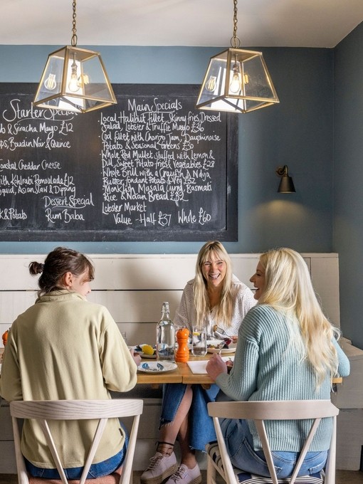 Three women eat lunch inside a restaurant