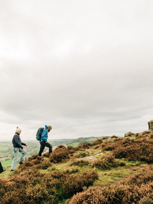 Three people, a man and two women walking up a ridge