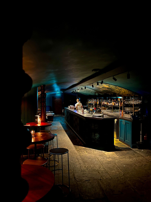 Inside a low lit cavernous empty bar.