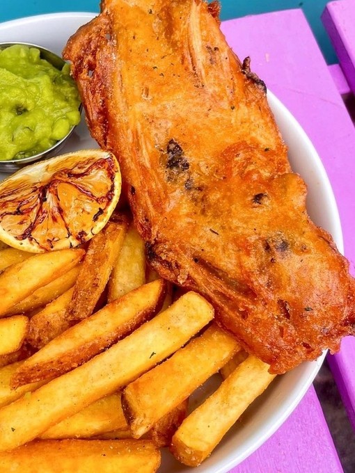 Fish and chips on a plate in Wholesome Junkies, Manchester