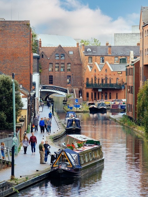 Canal boats and a towpath running alongside a canal in a city