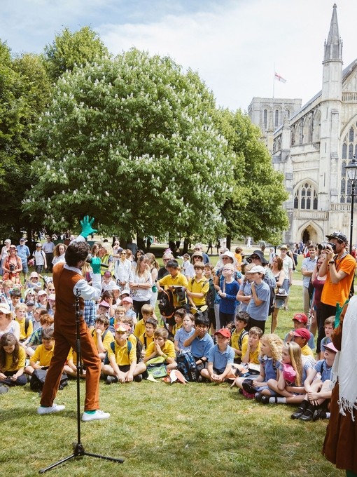 Performance in front of an audience on a lawn near cathedral
