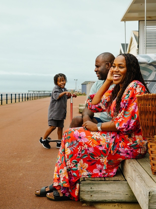 A family have fun at beach huts by the sea