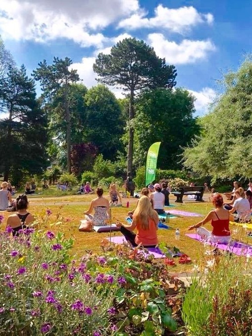 Groups of people taking a yoga session in a park on the Jurassic Coast