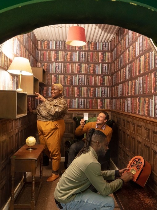 Three friends trying to work their way out of a small escape room style library