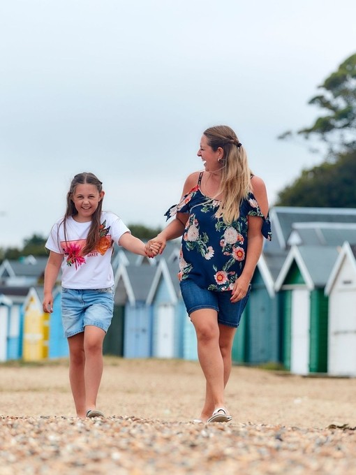 Family walking on a beach in front of beach huts