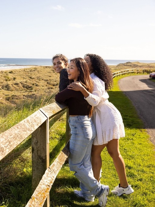 Friends looking out at the beach at Bamburgh Castle