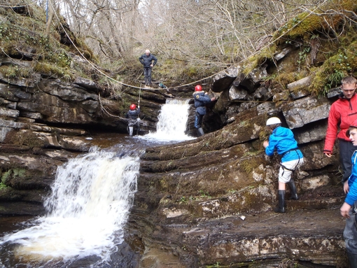 Children using a zipline across a waterfall at Alternative Adventure in Lancashire