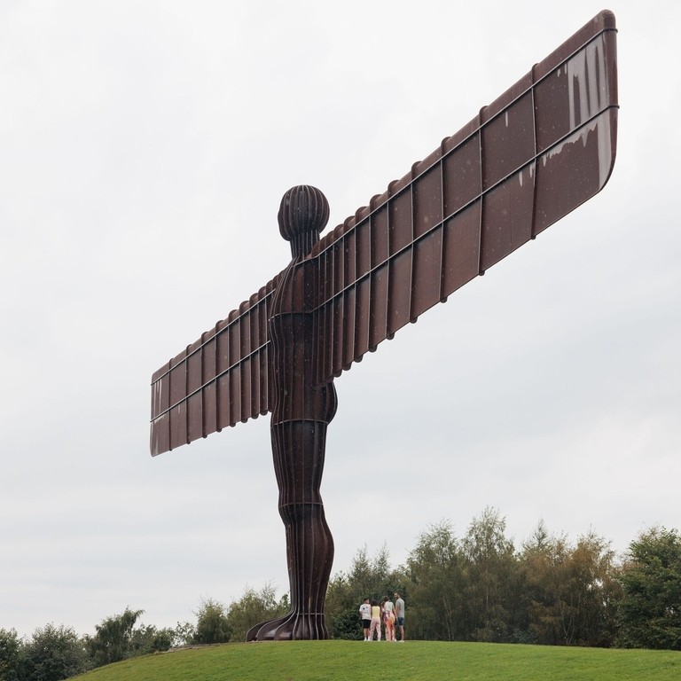 A family group visits the Angel of the North statue near Newcastle upon Tyne.