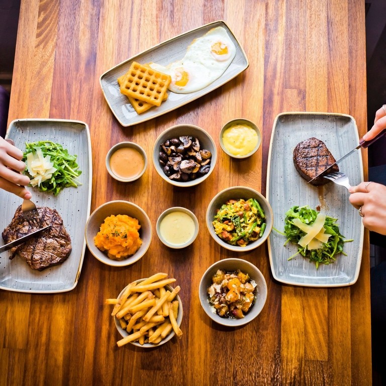 Two people eating steaks at Liverpool's Cowshed Restaurant