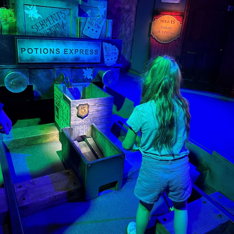 A child enjoying a wizard themed golf experience