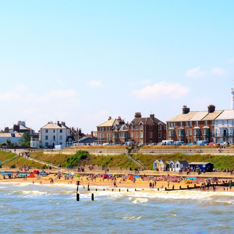 Beach with seaside cottages, beach huts and a lighthouse