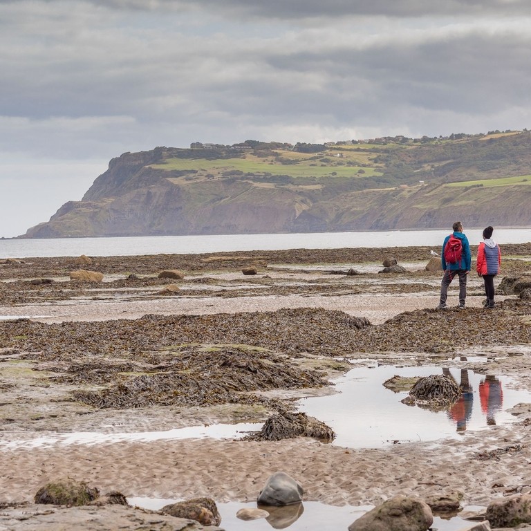 Couple on the beach with cliffs in the background