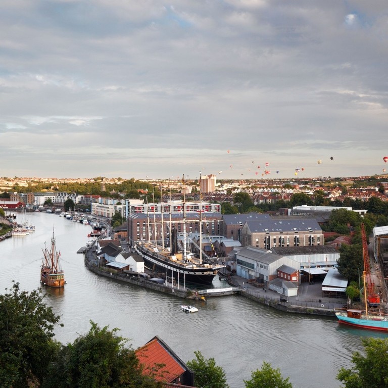 Cityscape showing boats and hot air balloons