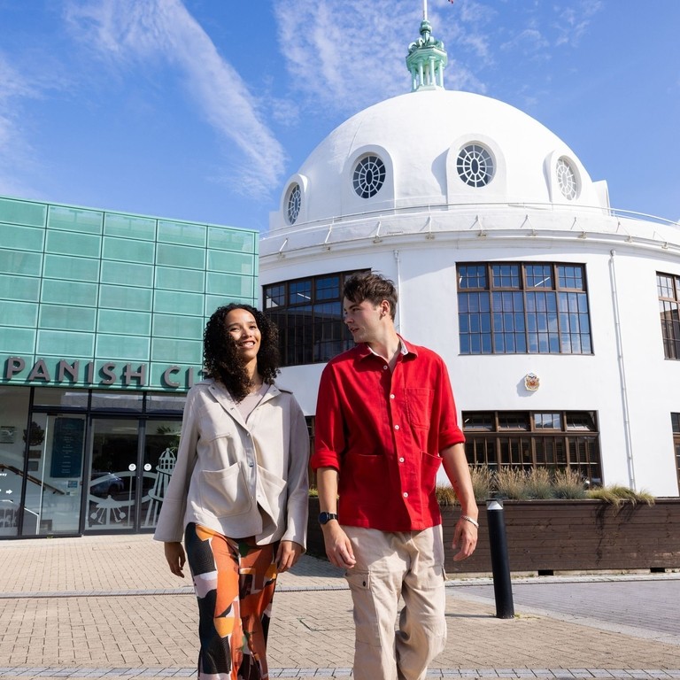 Two friends visiting an old art deco seaside building.