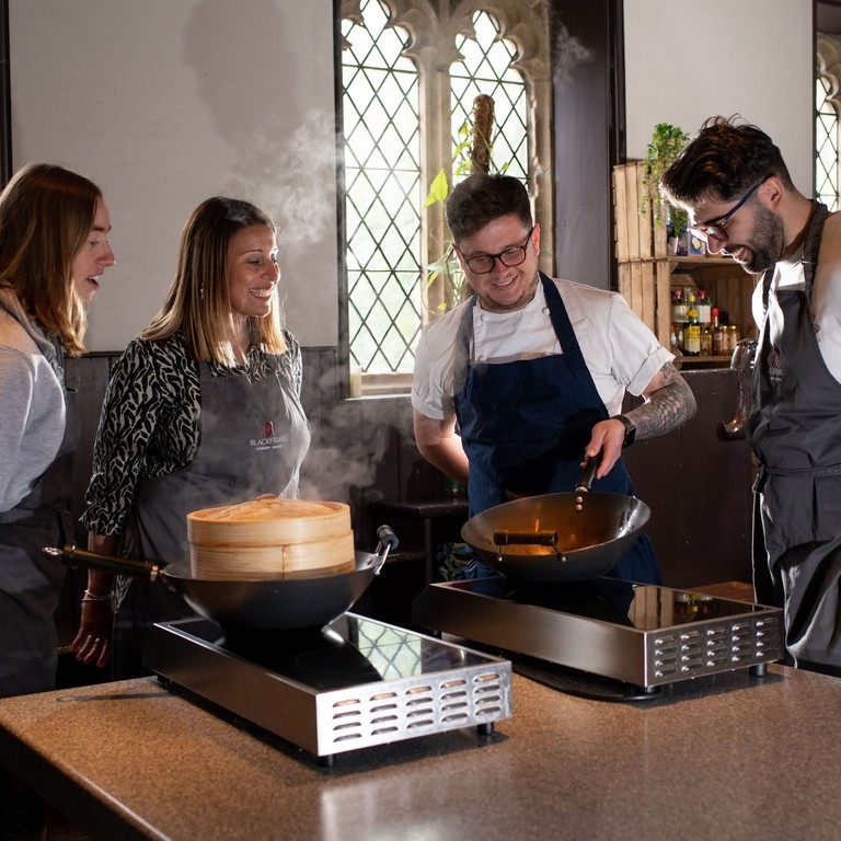 A group of people watch a cooking demonstration