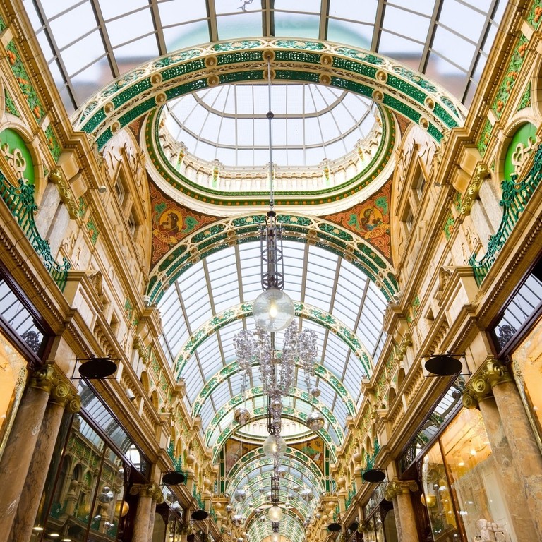 A majestic shopping arcade with ornate domed glass ceiling.