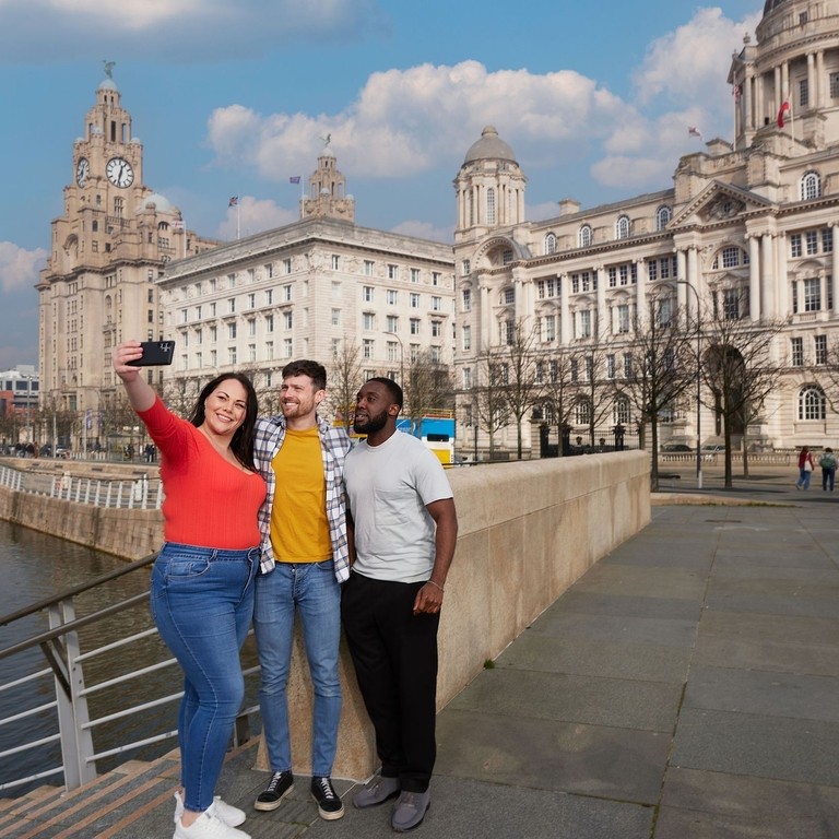 Friends taking a selfie by a city waterfront.