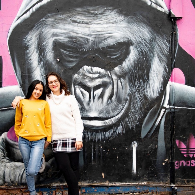 two people stand in front of Gorilla artwork by Gnasher