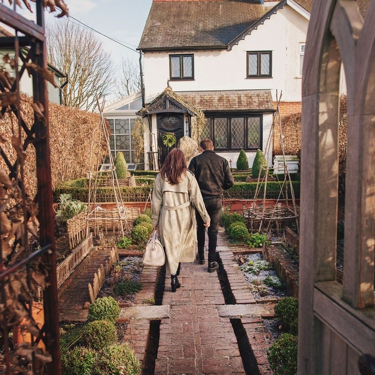 Man and woman walking towards a house